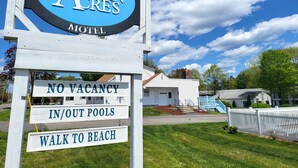 Een motelschild met 'Ocean Acres' en borden met 'Geen Kamers Beschikbaar', wat aangeeft dat het volgeboekt is.