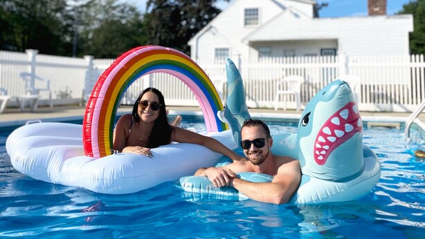 Zwembad met opblaasbare haai en regenbogenfloaters.