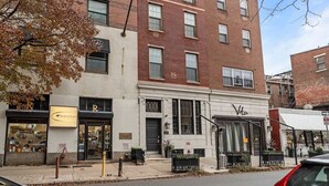 A multi-story building with a ground-floor storefront, a visible fire hydrant, and a tree with autumn leaves. - Beautiful 1BD With Balcony | Rittenhouse Square (Philadelphia)