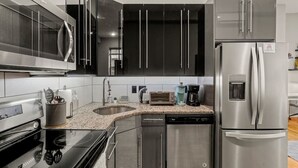 A modern kitchen with stainless steel appliances, a dishwasher, and a microwave. - Beautiful 1BD With Balcony | Rittenhouse Square (Philadelphia)