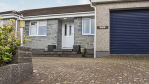 A residential house with a stone facade, a white front door, and a garage door. - 2 bedroom accommodation in Canonstown (Canonstown)