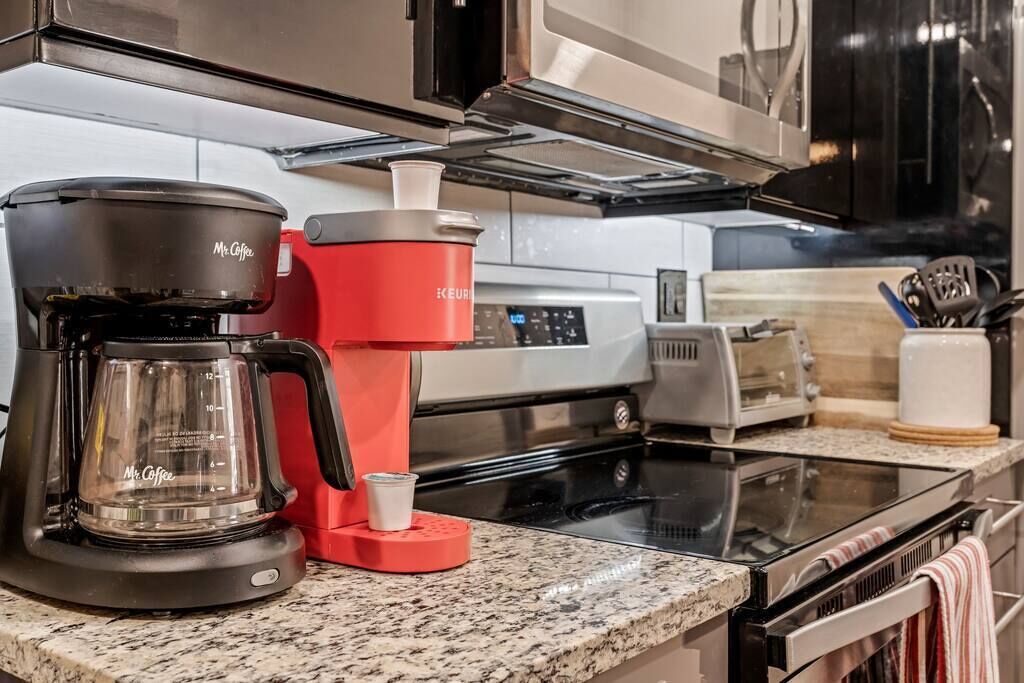 A kitchen with a coffee maker, toaster, and oven.