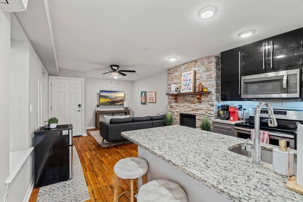 A modern kitchen with granite countertops, a built-in microwave, and a stainless steel oven.