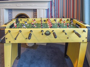 A foosball table with a fireplace in the background.