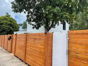 Leading to a serene residential setting, this charming entrance features a traditional wooden fence and a beautiful tree.