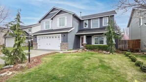 A two-story house with a garage, a well-maintained lawn, and a small tree in the front yard. - Upscale House for up to 20 with Fire Pit & Pool (Meridian)