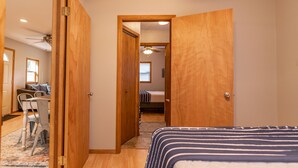 Un dormitorio con cama, armario de madera y una zona de comedor con sillas y mesa.