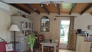 Un vaste espace de vie comprenant une table à manger, des chaises, un canapé, une lampe et un meuble.