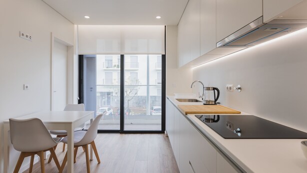 A modern kitchen with a dining area, large windows, and a view of the outside. - An accomodation very close to Ponta Delgada! (Ponta Delgada)