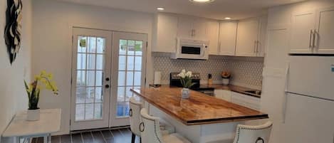 Refrigerador, cafetera y tetera y isla de cocina