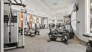Une salle de sport équipée de divers appareils d’exercice, notamment des tapis de course et des appareils de musculation.