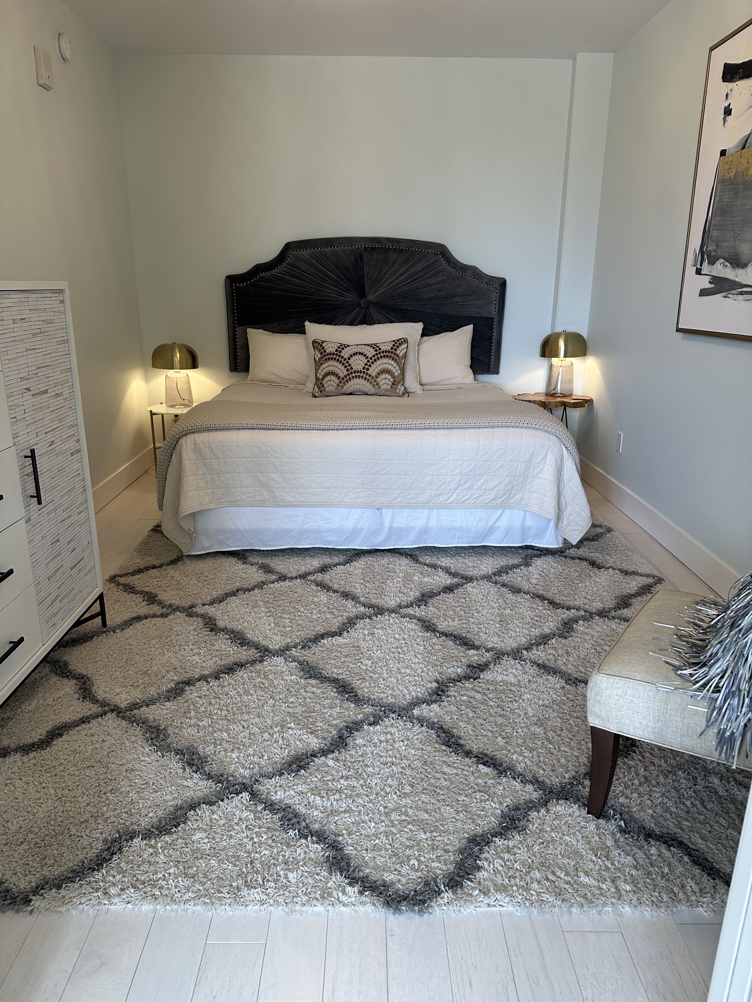A bedroom with a bed, two bedside tables, a nightstand, a chair, and a wardrobe.