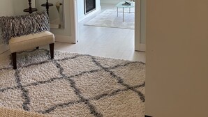 Een moderne woonkamer met een bank, een grote spiegel, een open haard en een televisie.