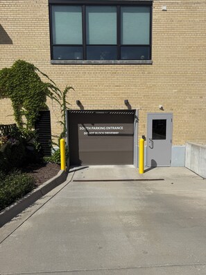 A building entrance with a sign indicating a south parking entrance and a clearance height of 7 feet 1 inch. - Asylum 58 Condo @ Grand Traverse Commons (Traverse City)