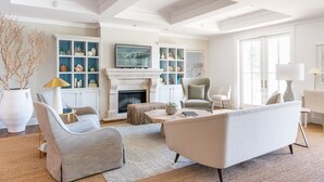 A modern living room with a fireplace, comfortable seating, and built-in shelving with decorative items.