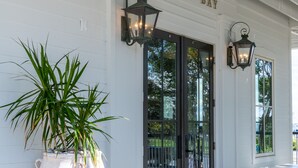 A white building with a sign reading "OYSTER BAY" and a large planter with green plants.