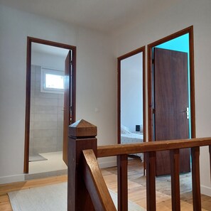 Ein Zimmer mit einer Holztreppe, einem Bett und einem Fenster.