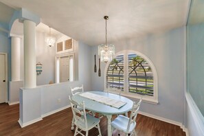 Enjoy meals in this dining area with a round table for four, surrounded by comfortable chairs and a stunning view of the outdoors.
