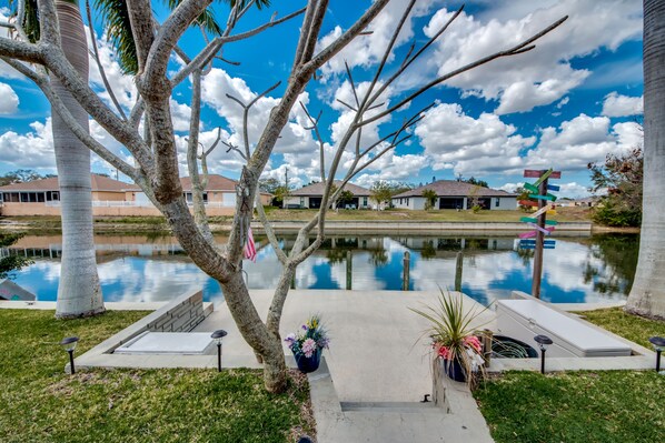 Stroll through a serene lawn to a tranquil pond, surrounded by a residential area.