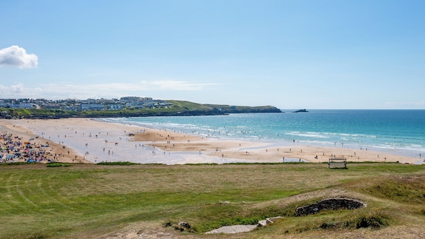 A beach with people, a grassy area, and buildings in the background. - 2 bedroom accommodation in Newquay (Newquay)