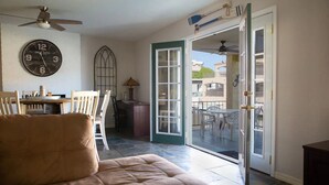 A room with a large clock, a dining area, and a sliding glass door leading outside. - Waterfront Parker Strip - Private 50' Dock - Moovalya Keys (Parker)