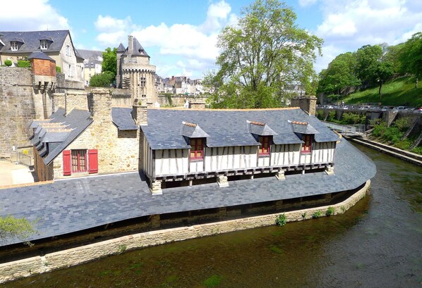 A riverside building with a stone facade and a curved roof.