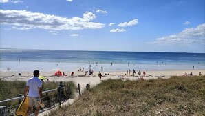 Ein Strand mit Menschen und einem klaren Himmel.