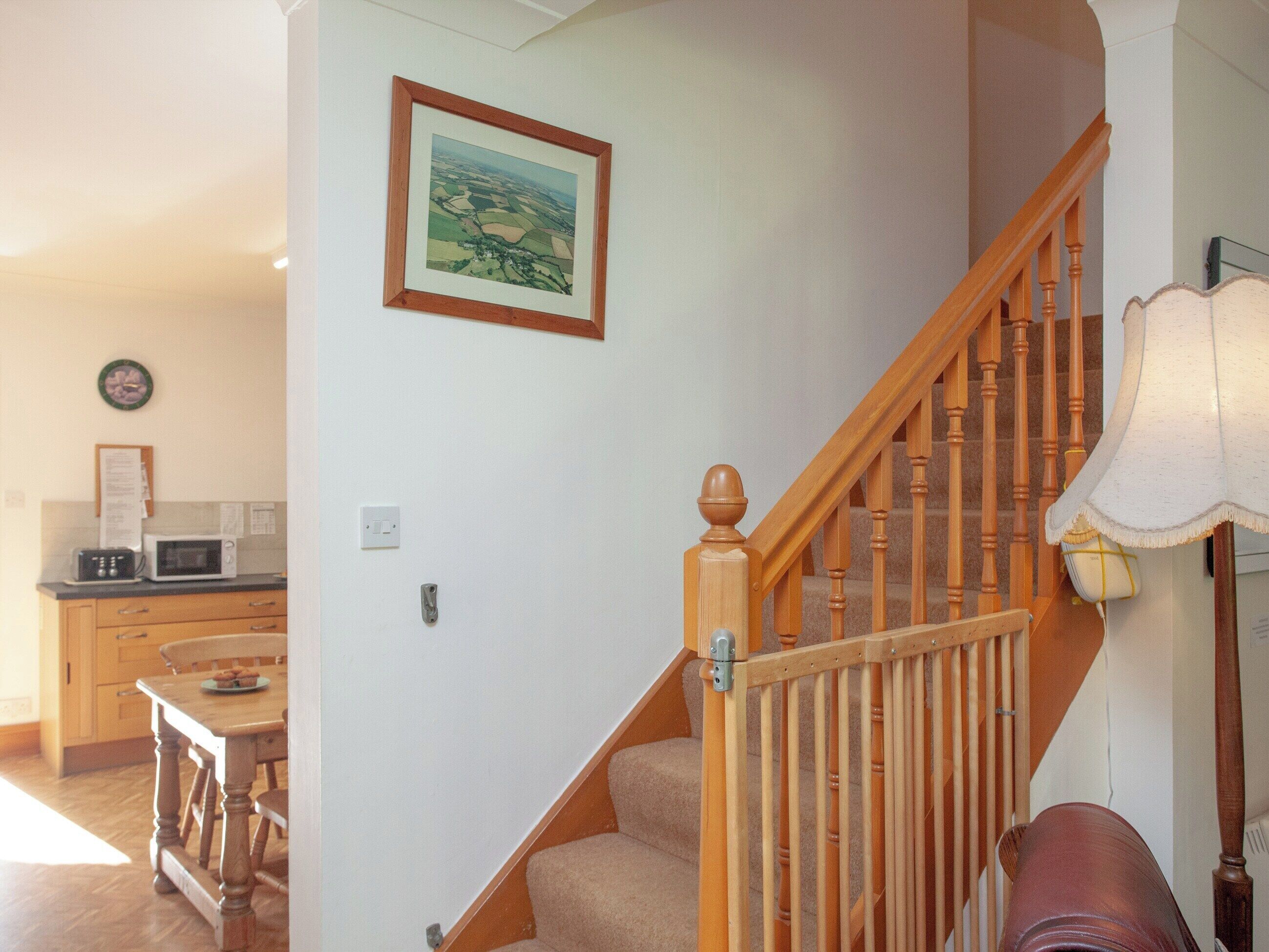 A staircase with wooden balusters and a handrail, leading to an upper floor.