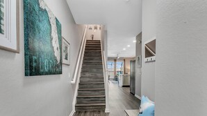 Un intérieur moderne avec un escalier en bois, un coin cuisine et un espace repas.