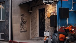 Un edifici amb façana vermella, part superior blava i un rètol que diu 'Candy Boutique'.