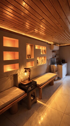Ein Spa-Raum mit Holzbänken, Regalen an der Wand und einem Wasserspender.