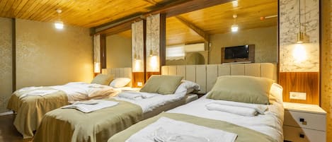 Comfort Quadruple Room | Peralatan tempat tidur premium, bar mini, peti besi dalam bilik, meja