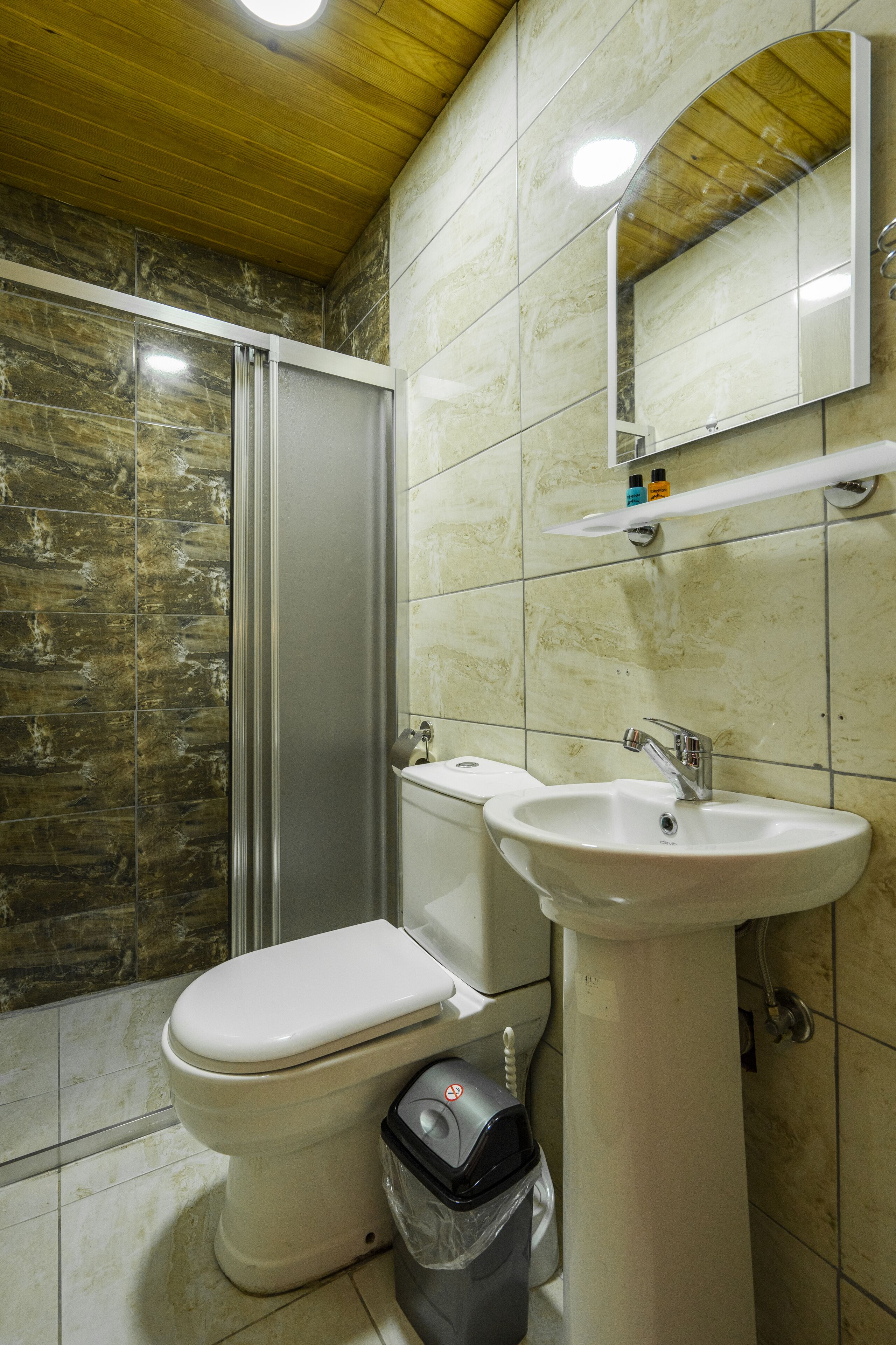 A bathroom with a toilet, sink, and shower.