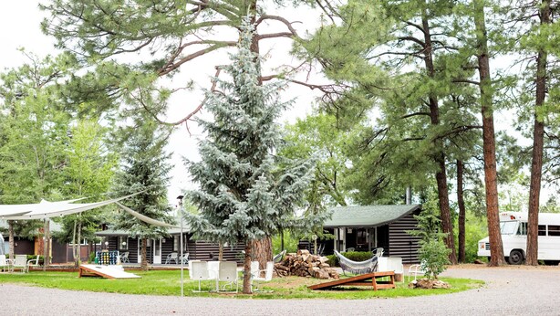 A rustic cabin with a hammock, outdoor seating, and a covered area. - Corduroy Boutique Lodge (Pinetop)