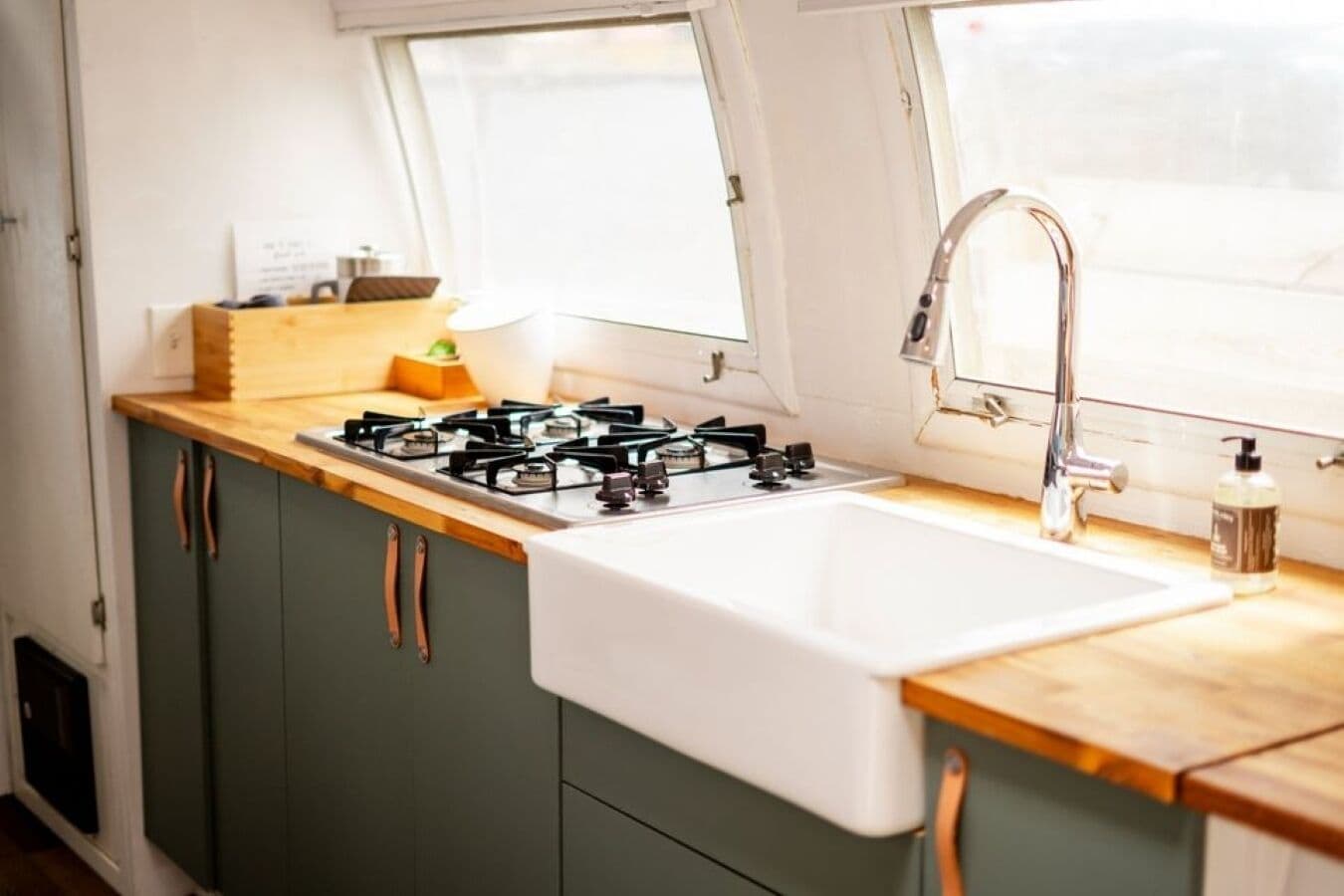 A compact kitchen with a gas stove, a sink, and a window.