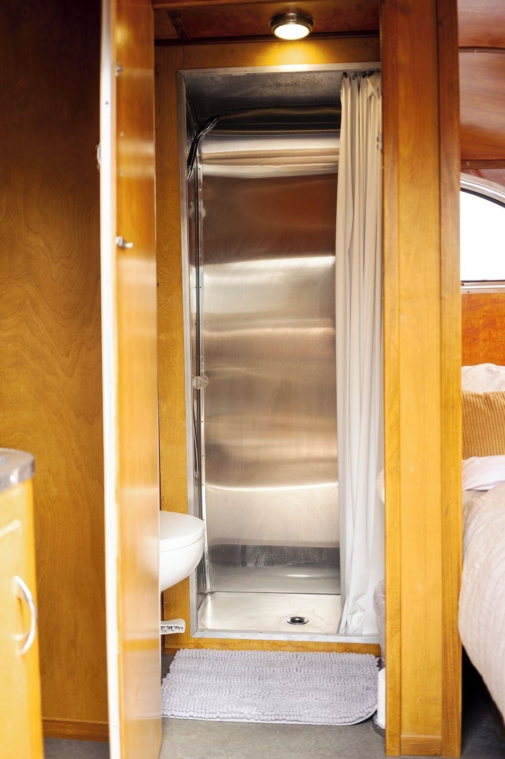 A compact bathroom with a shower, toilet, and sink.