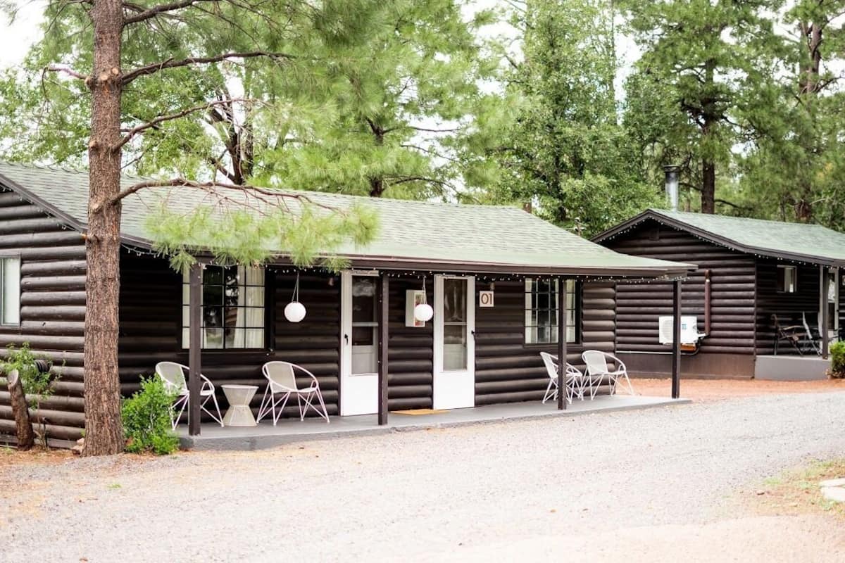 Eine Blockhütte mit Veranda, Sitzgelegenheit im Freien und einem Schild mit der Zimmernummer 01.