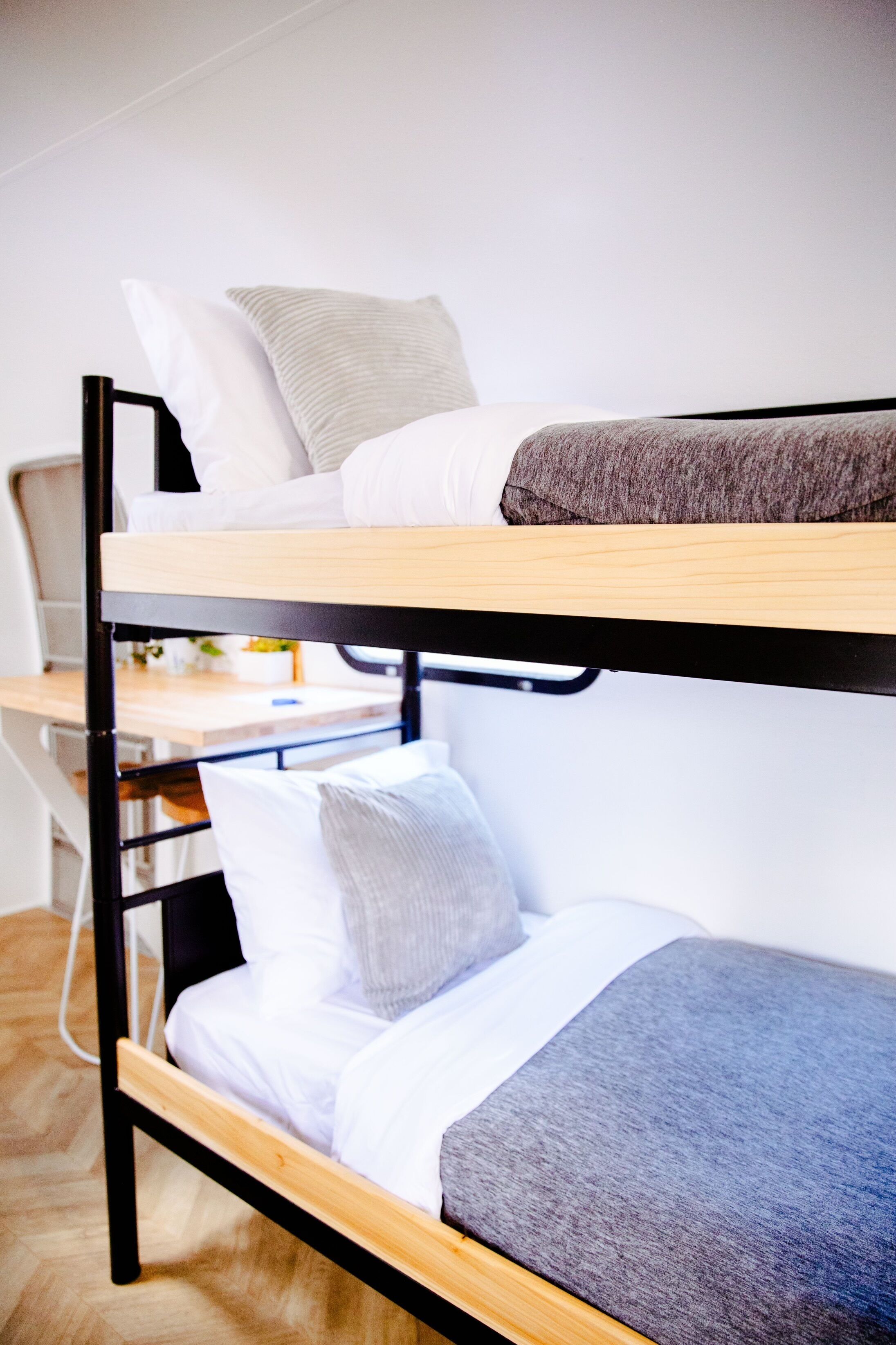 A bunk bed with two levels, each with pillows and a blanket.