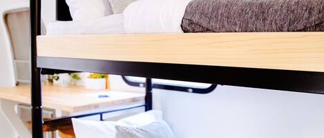 A bunk bed with two levels, each with pillows and a blanket.