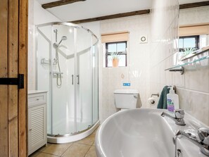 Une salle de bain moderne avec une douche à parois de verre, une baignoire sur pieds et des toilettes.