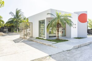 A modern building with a white facade, large glass windows, and a prominent red circle on the right side. - OYO Hotel Rio Chetumal (Santa Elena)