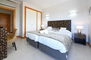 A hotel room with a bed, two bedside tables, a chair, and a wardrobe. - Vista Golf 9 (Maspalomas)
