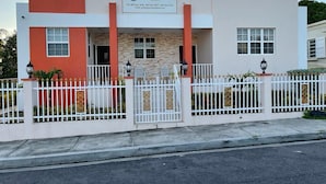 A modern hotel with a prominent sign, a gated entrance, and a well-maintained exterior. - The Golden Gate Inn (Basseterre)