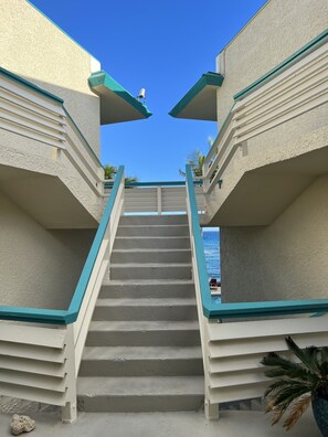 A staircase leading to a balcony with a view of the ocean.