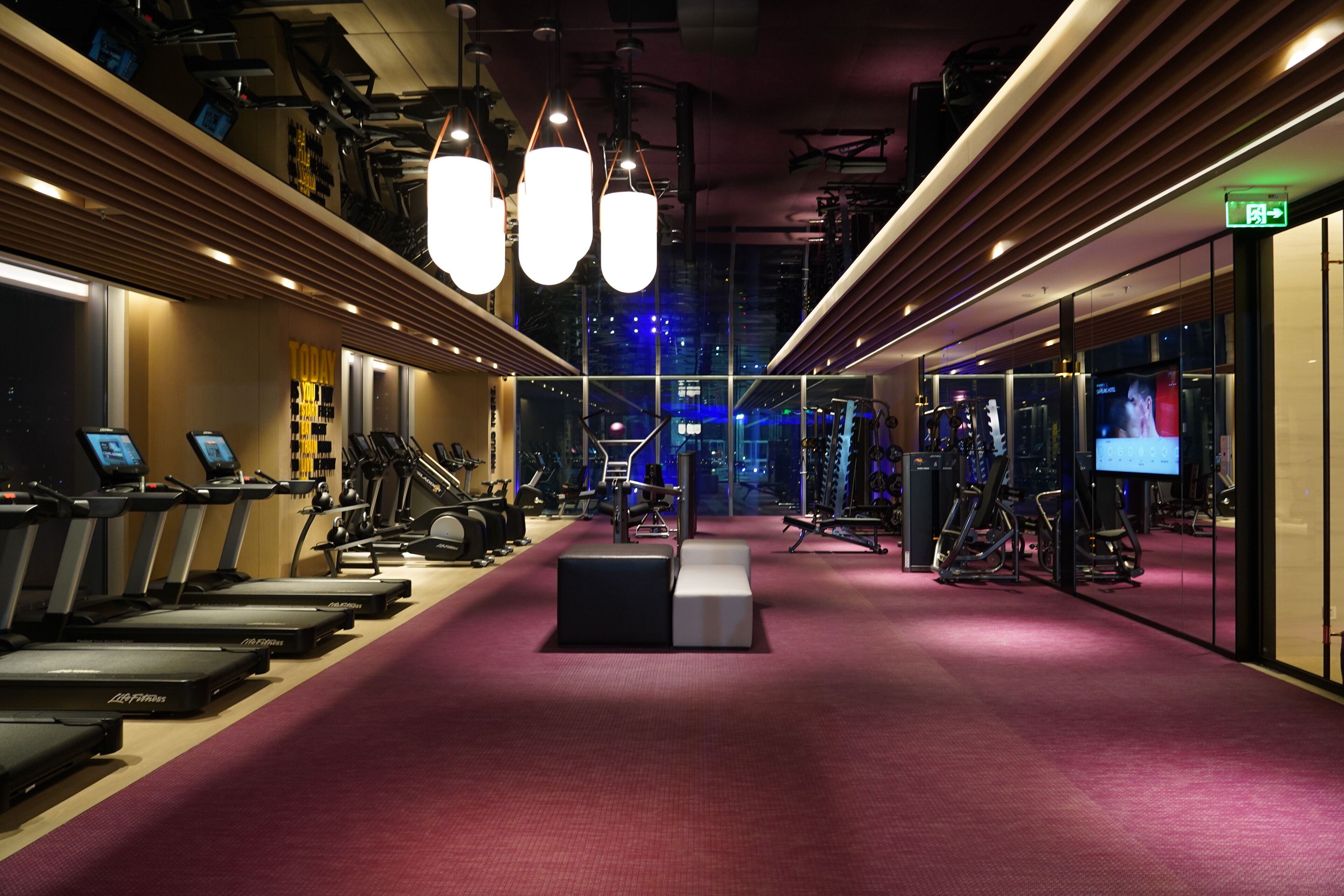 Un gimnasio con cintas de correr, pesas y equipo de ejercicio.