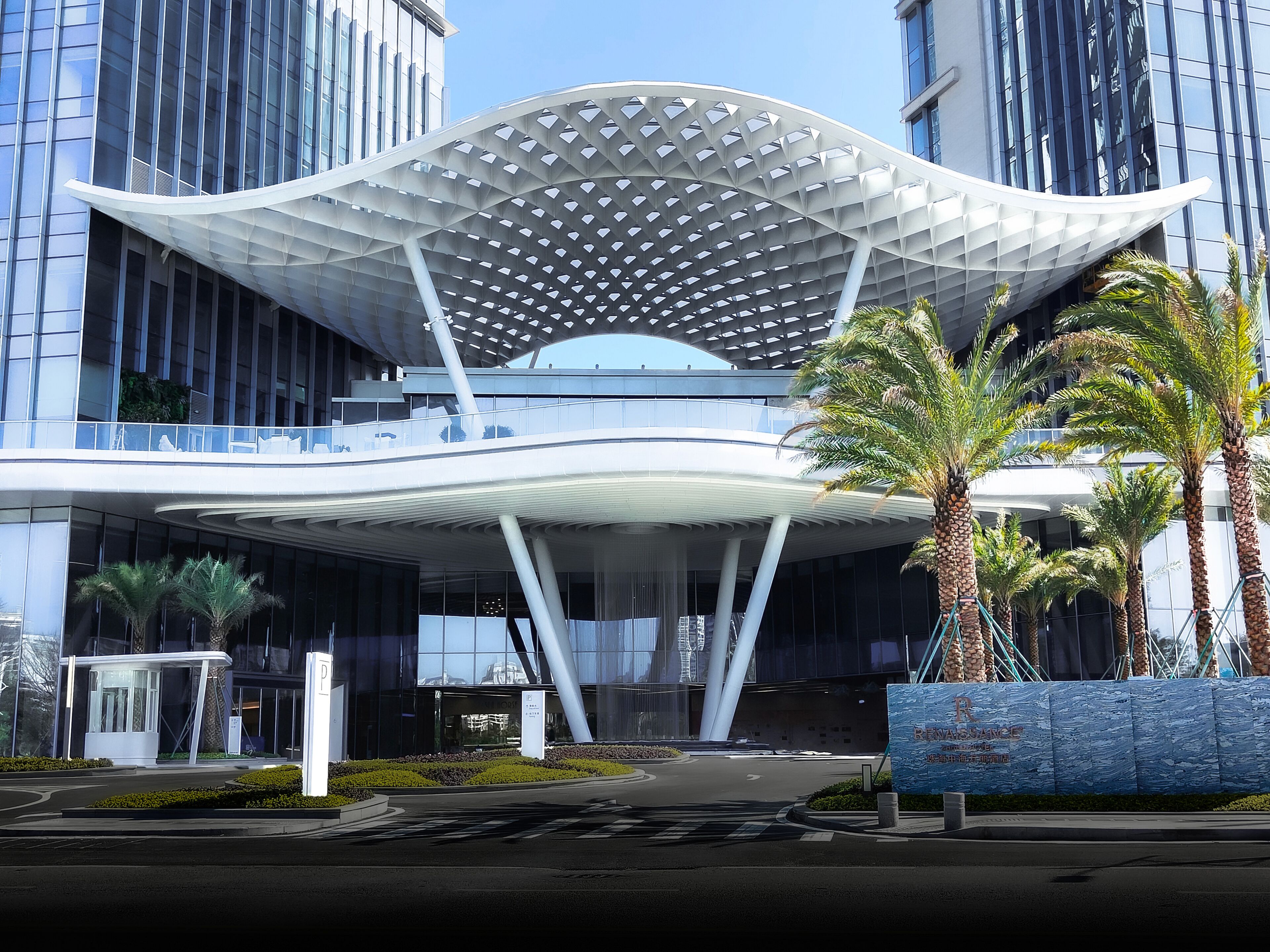 Un edificio moderno con una estructura de techo curvada y fachada de vidrio.