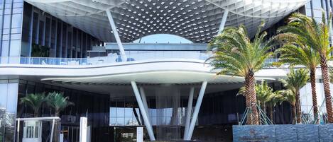 A modern building with a unique curved roof structure and a glass facade.
