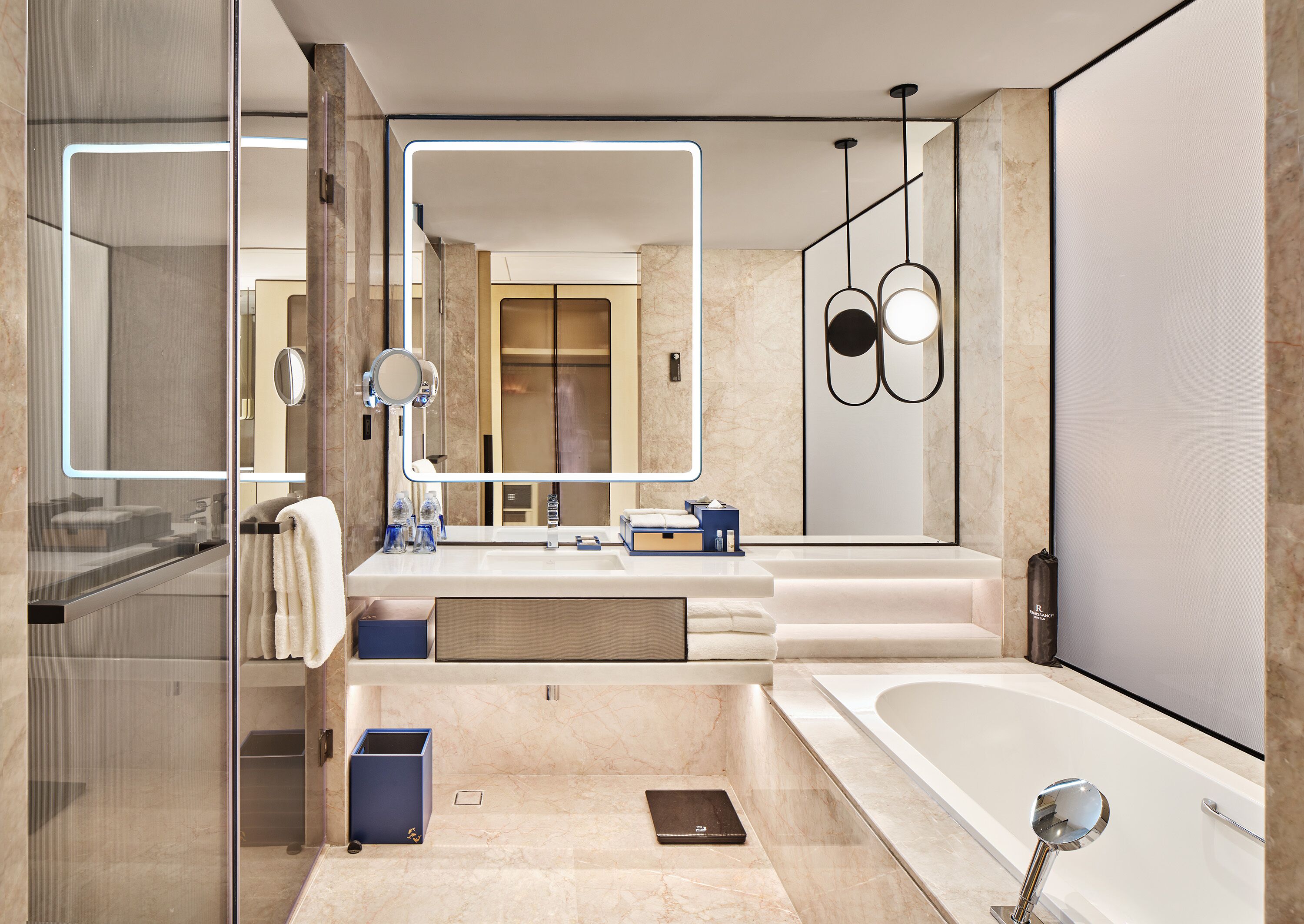A modern bathroom with a large mirror, a bathtub, and a shower area.