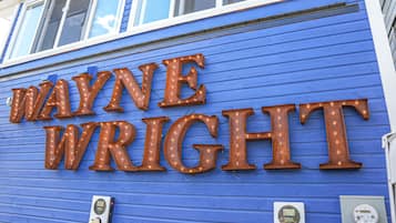Un edificio con fachada azul y letras iluminadas que dicen "WAYNE WRIGHT".