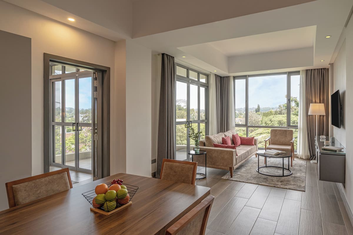 Un grand espace de vie comprenant une table à manger, un canapé et un téléviseur fixé au mur.